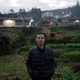 Wang Quanming poses for a photograph near his family home where he lived until he was 15 years old, in Anxi county, Fujian province.